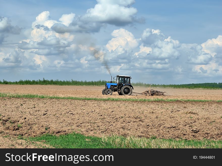 Tractor in the field. Planting work. Plow. Plowing the land.