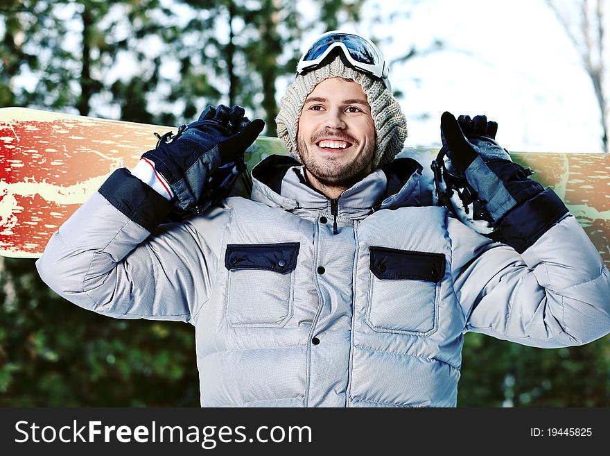 Shot of a young man with a snowboard outdoor.