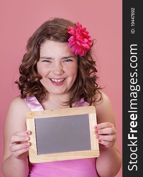 Smiling young preteen holding a mini chalkboard for school. Smiling young preteen holding a mini chalkboard for school
