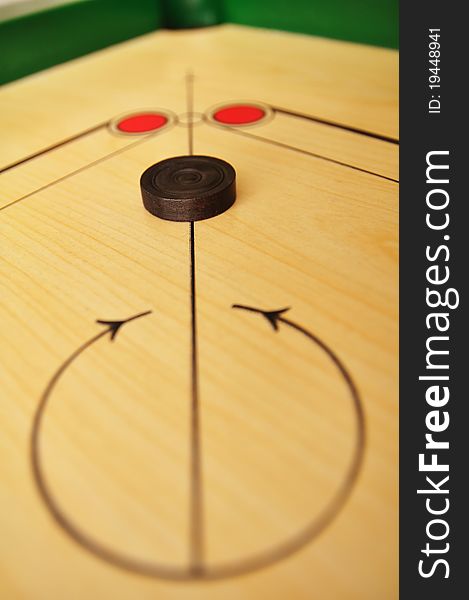 Photo of carrom board and coin.