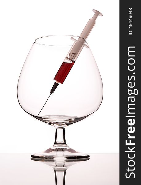 The syringe with narcotic in empty wineglass. The syringe with narcotic in empty wineglass