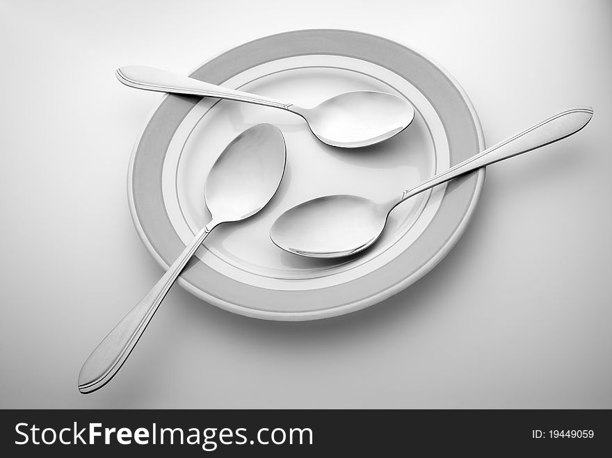 Three spoons lie on a plate. Three spoons lie on a plate