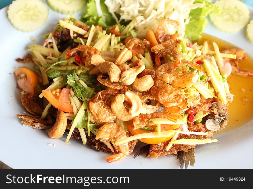 Thai food, deep fried fish with green mango salad
