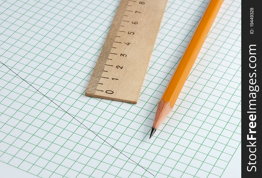 Pencil and ruler on a checkered paper