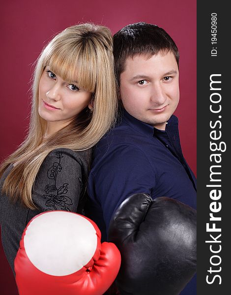 Attractive family couple in  boxing gloves on red