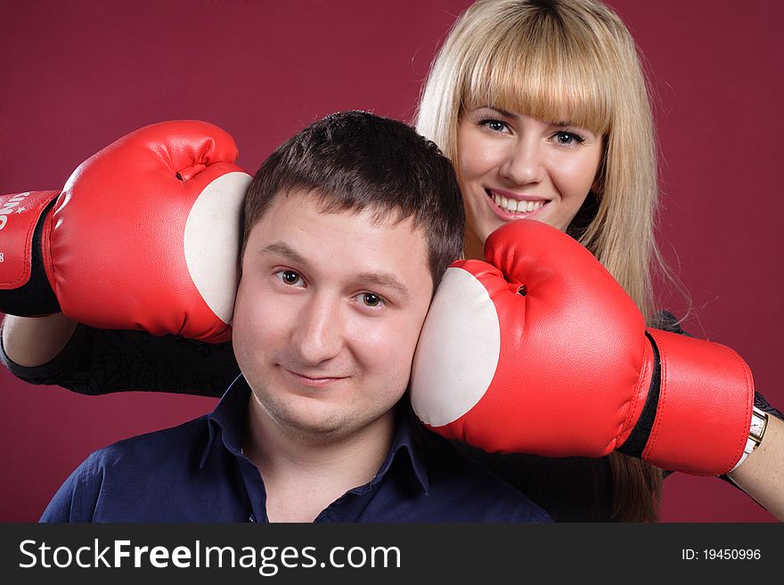 Attractive family couple in  boxing gloves on red