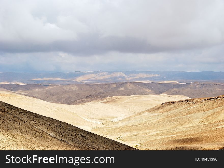 Fragment of ancient desert under dramatic sky. Desert Negev, Israel.