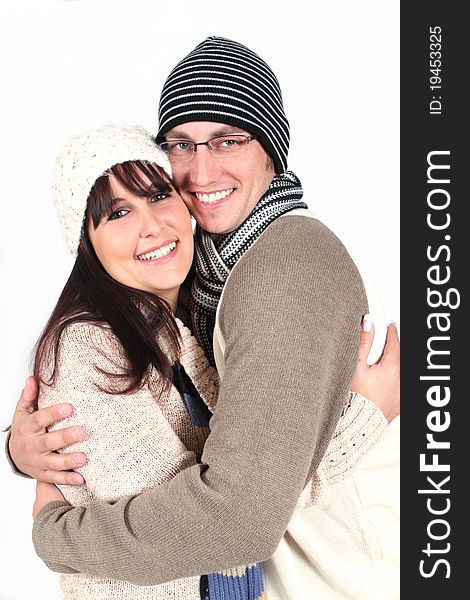 Young couple hugging in winter clothes on white background