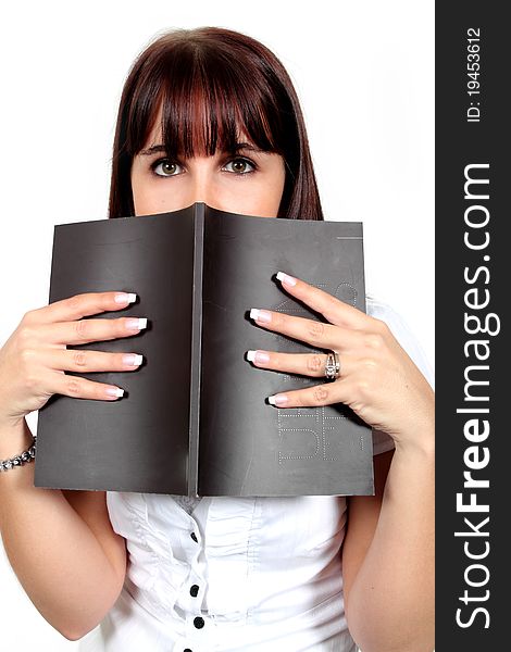 Young woman peeking over the top of a black book. Young woman peeking over the top of a black book