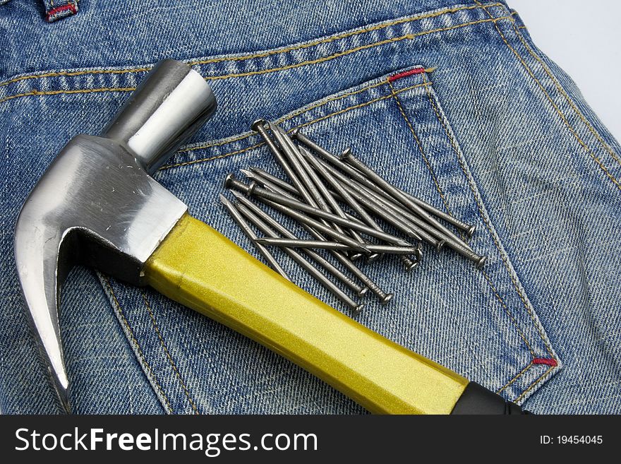 Hammer and nails on jeans in concept of carpenter