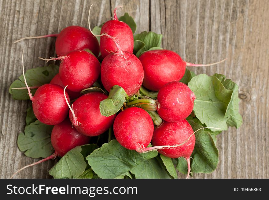Bunch of fresh radishes on old wooden table