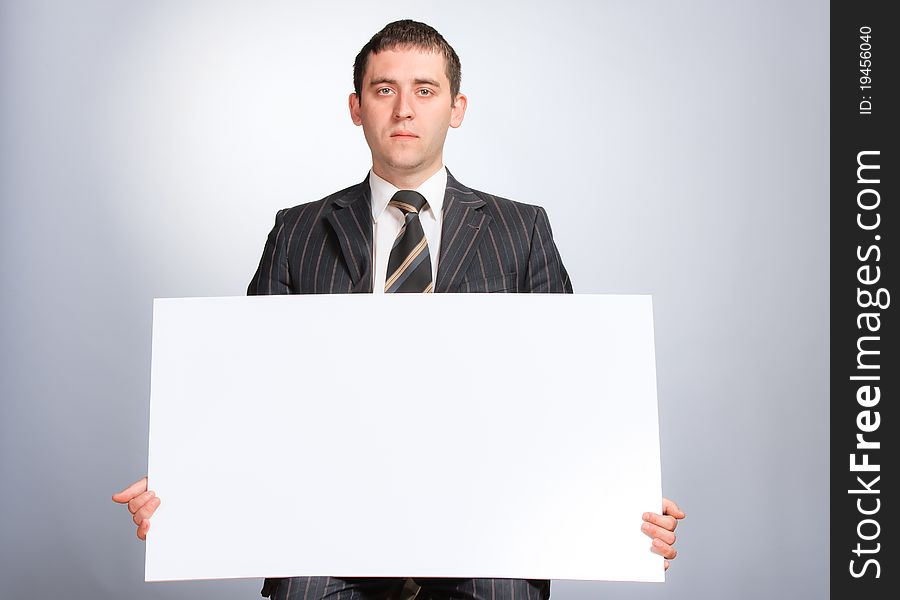 Business man holding a white card looking very serious. Business man holding a white card looking very serious