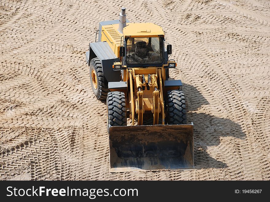 Big yellow excavator in sand pit