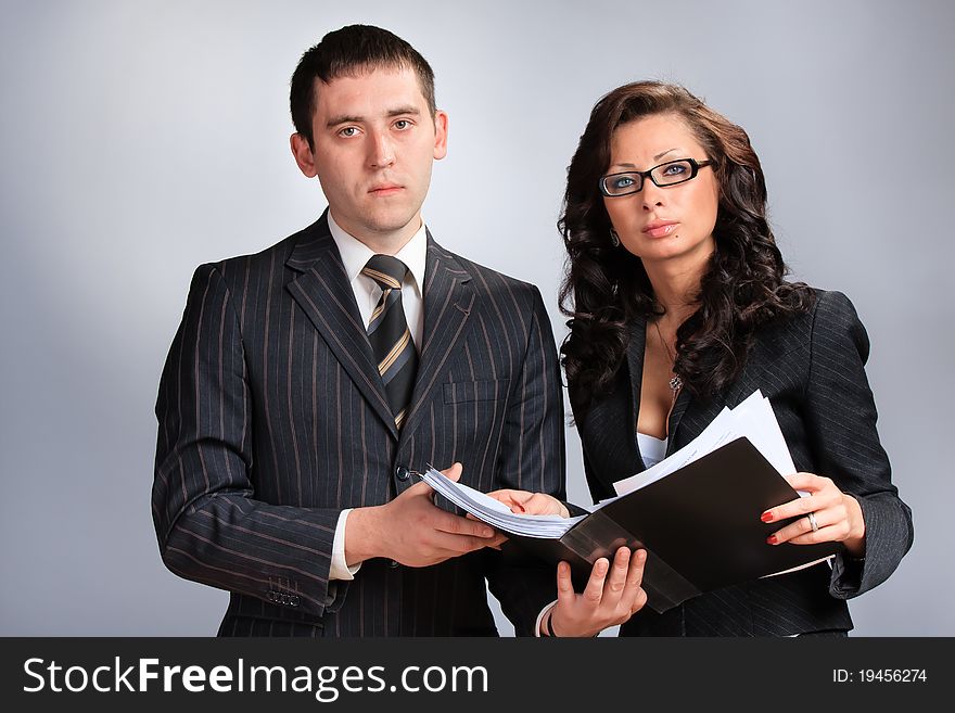 Portrait of business woman and man reading a document. Portrait of business woman and man reading a document