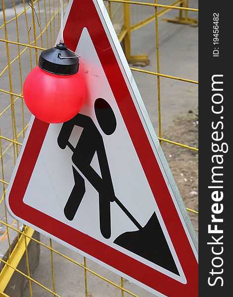 The road work sign with big red lamp. The road work sign with big red lamp