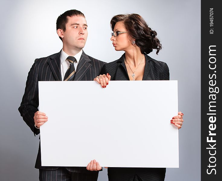 Young couple presenting a blank board over white background. Young couple presenting a blank board over white background