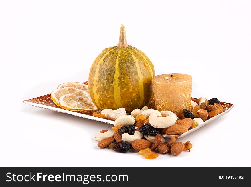 Pumpkin With Candle Lemon And Nuts On The Plate