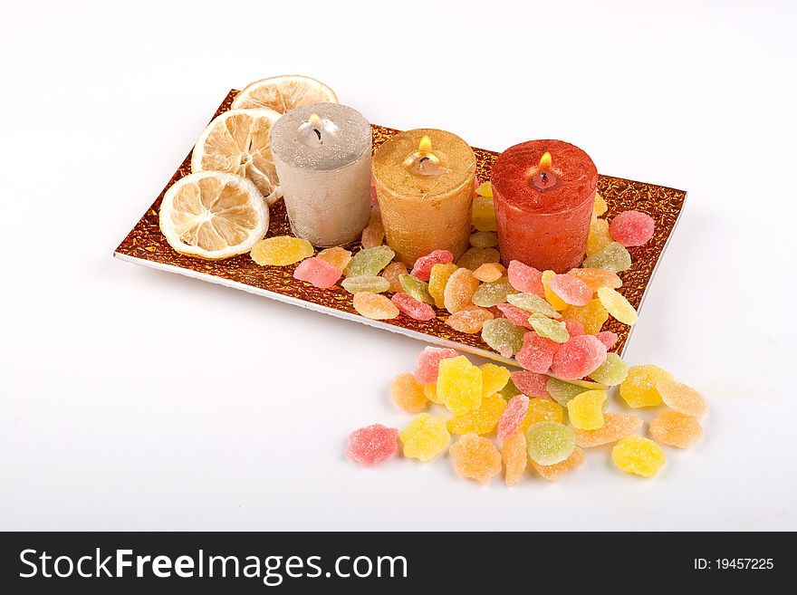 Burning candles with lemon and candy on the rectangle plate.