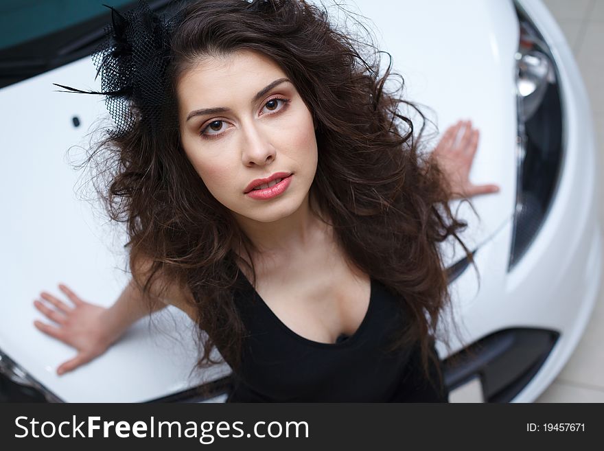 Young woman on white hood of New car