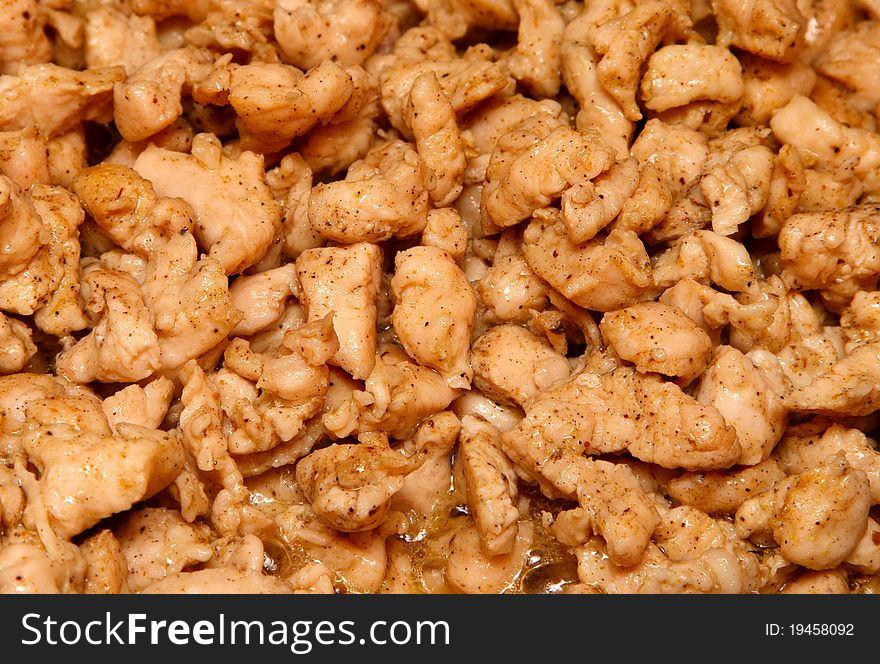 Slices of chicken fried in vegetable oil.