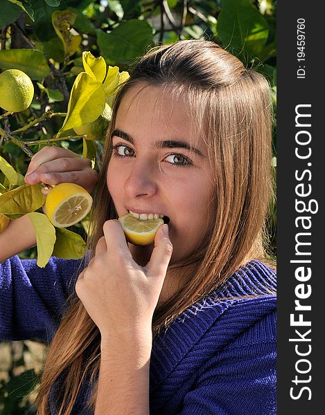 Girl eating a lemon from the tree