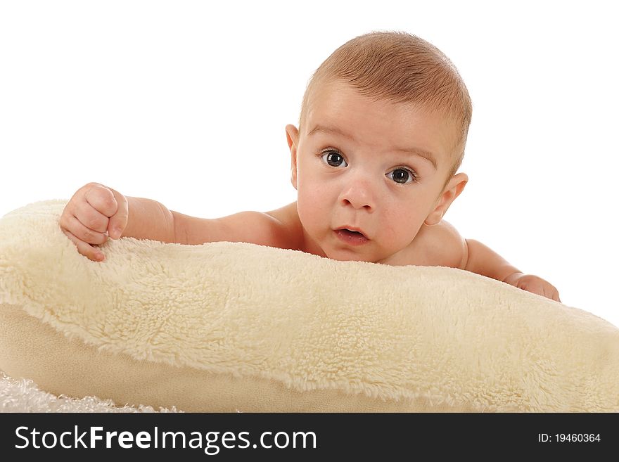 A close-up portrait of an adorable baby boy on a fluffy white pillow. Isolated on white. A close-up portrait of an adorable baby boy on a fluffy white pillow. Isolated on white.