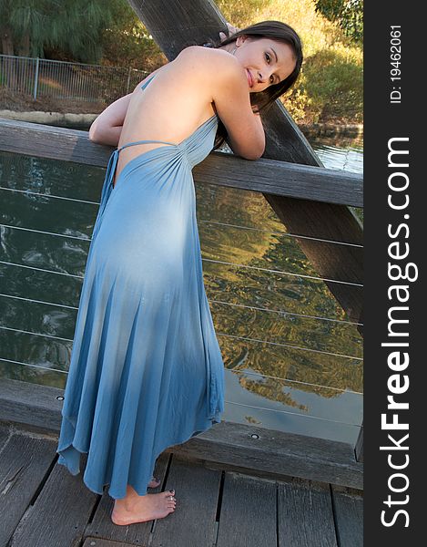 A young woman in a blue dress posing outdoors. A young woman in a blue dress posing outdoors.