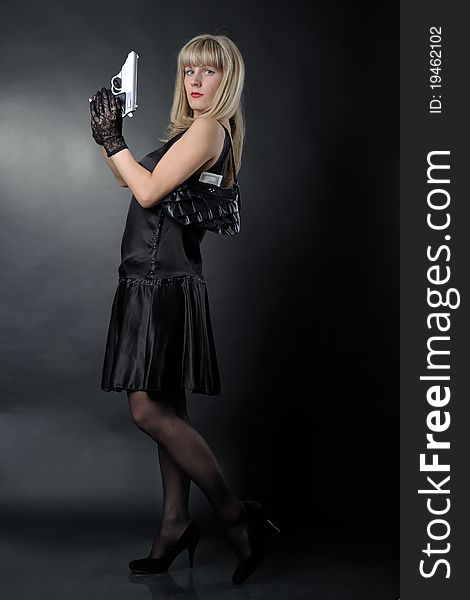 Gangster woman with pistol in black