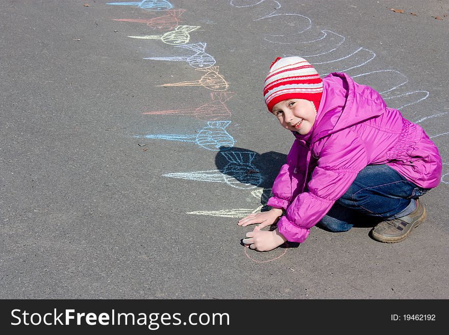 Girl drawing on the asphalt.