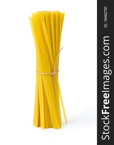 An image of raw yellow pasta on white background