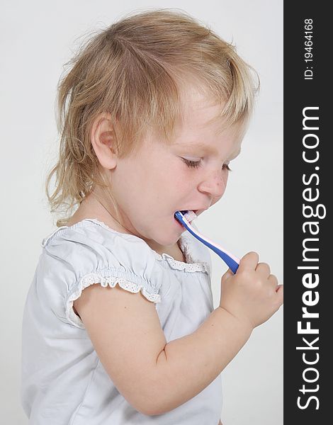 Cute child cleaning teeth over white. Cute child cleaning teeth over white
