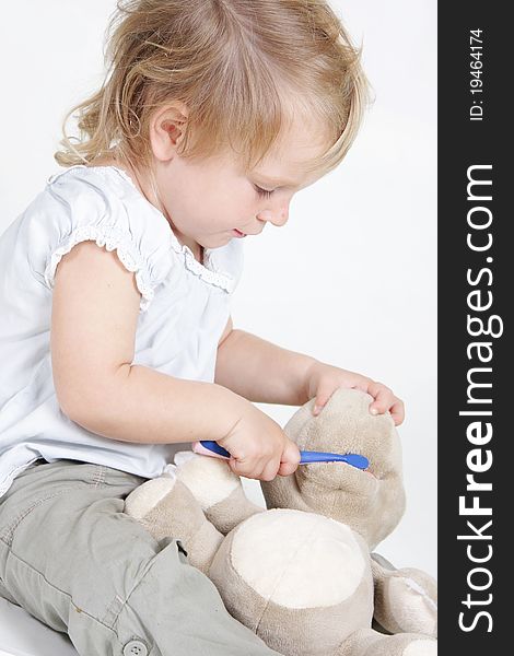 Cute child cleaning teeth to no-name toy hippo