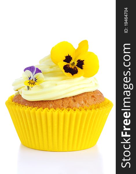 Cupcake with cream and decorated with violets on white isolated background