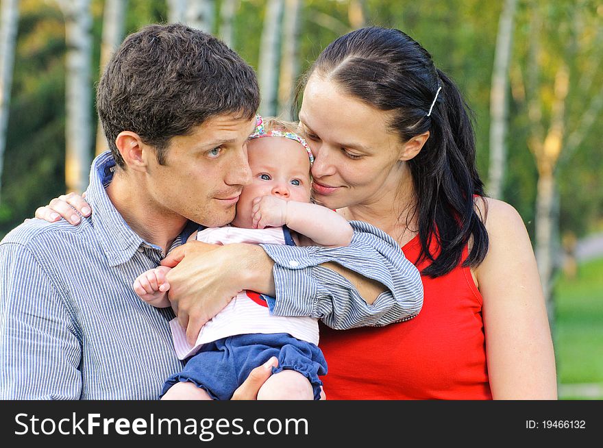 Happy mom and dad with their little daughter for a walk in the park. Happy mom and dad with their little daughter for a walk in the park