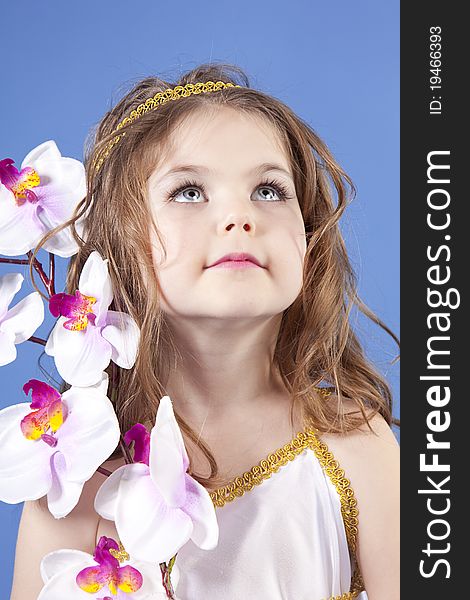 Beautiful girl in the dress of the goddess holding a flower