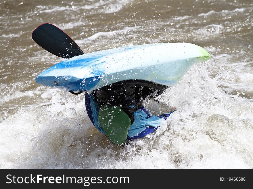 Close-up on kayaker fighting rapids of a river