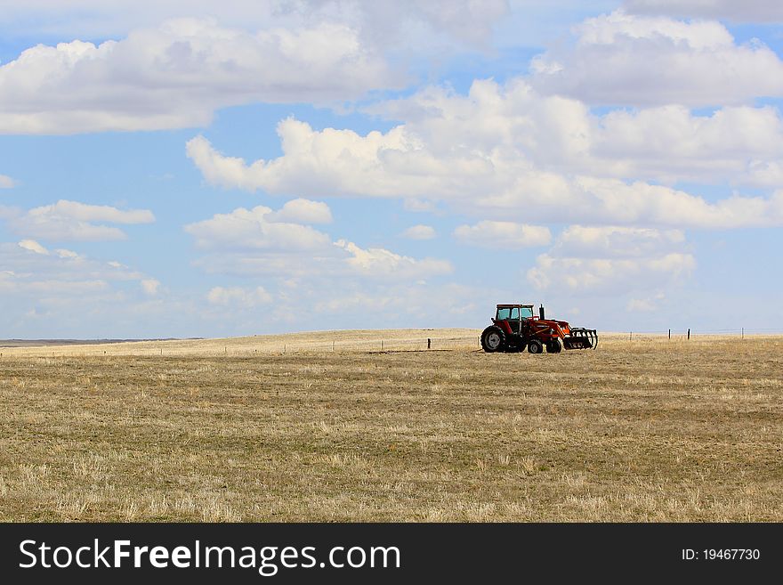A tractor sitting unused in a farm field in Southeastern Wyoming. A tractor sitting unused in a farm field in Southeastern Wyoming