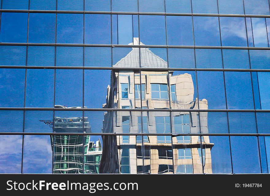 Buildings reflected in the mirrored windows of a modern building