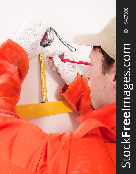 Construction worker doing measuring on the wall