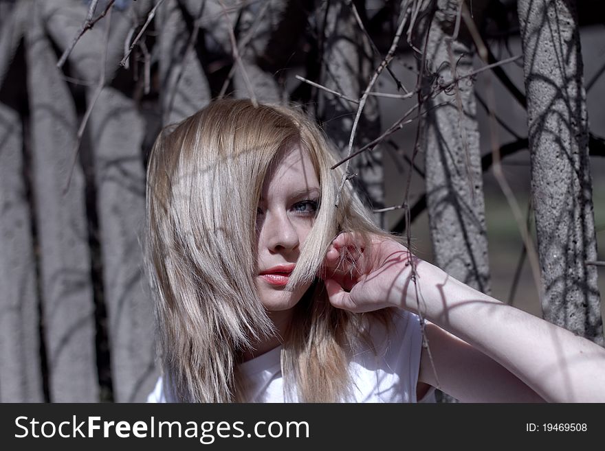 Beautiful caucasian blonde woman near old fence