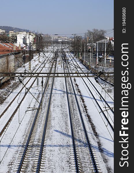 Train tracks in snow covered cityscape