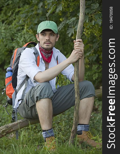 Hiker with backpack resting on a tree. Hiker with backpack resting on a tree
