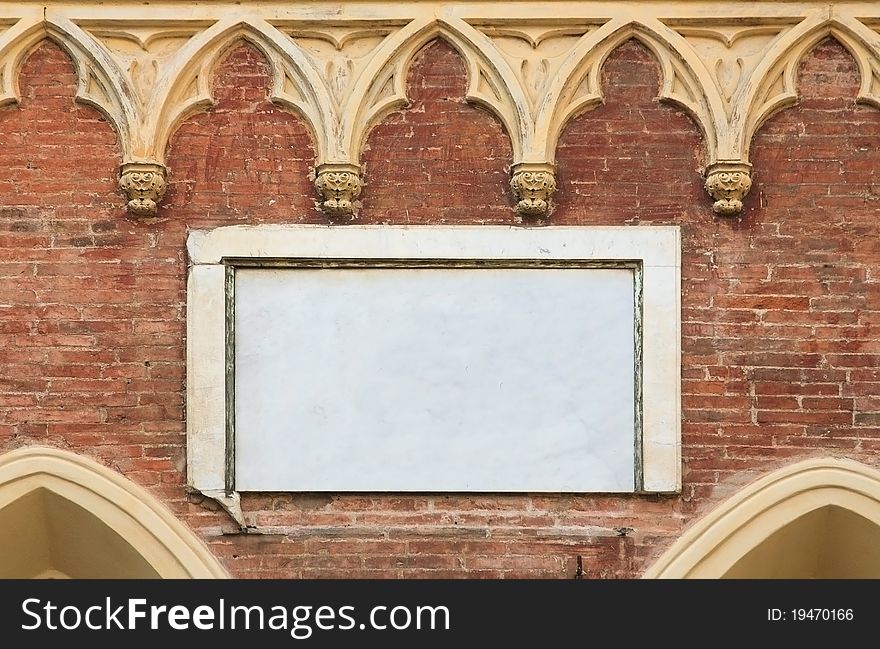 A blank marble plaque on the wall of an old brick building in Europe, with ornate stonework. Room for text. A blank marble plaque on the wall of an old brick building in Europe, with ornate stonework. Room for text.