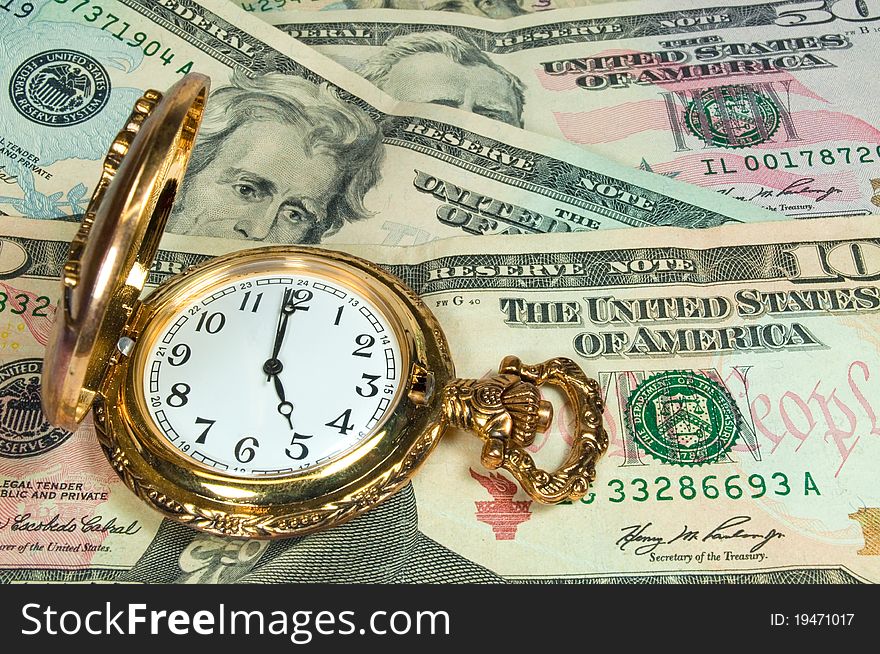 A gold pocketwatch on some US currency. A gold pocketwatch on some US currency
