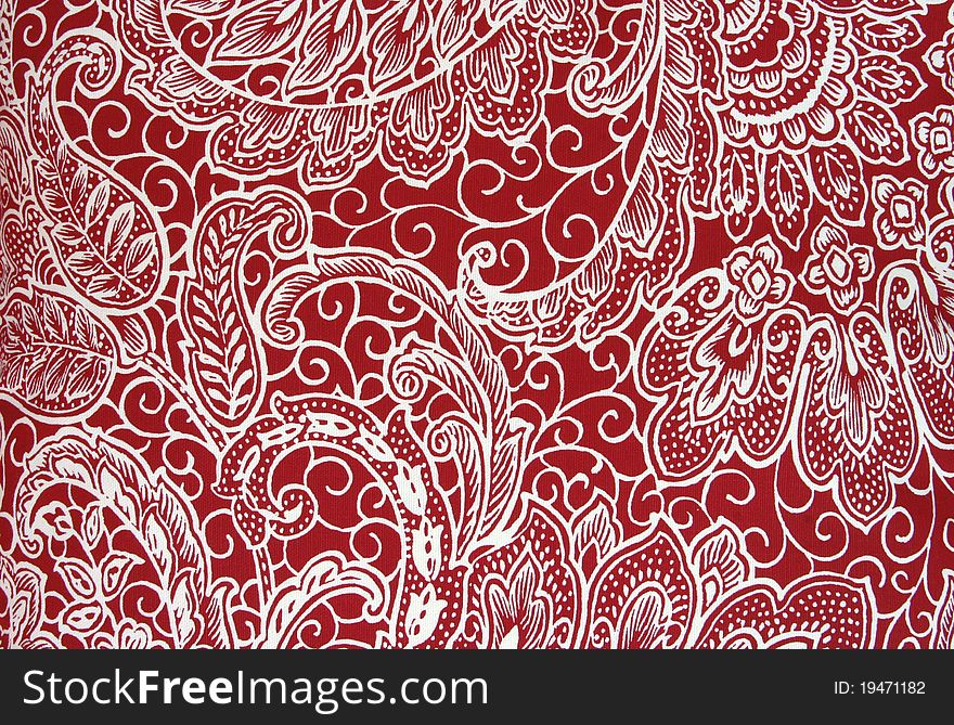 Red fabric with a printed white floral/paisley pattern