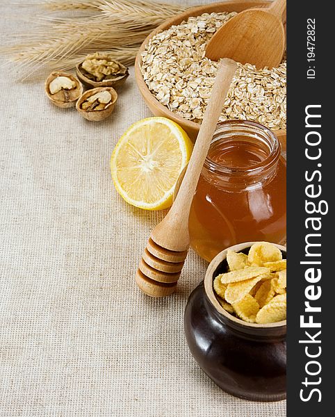 Plate of oat, honey and healthy food on sacking