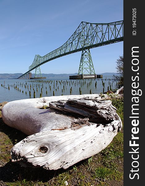 The Astoria bridge and a log near the shoreline, Astoria Oregon. The Astoria bridge and a log near the shoreline, Astoria Oregon.