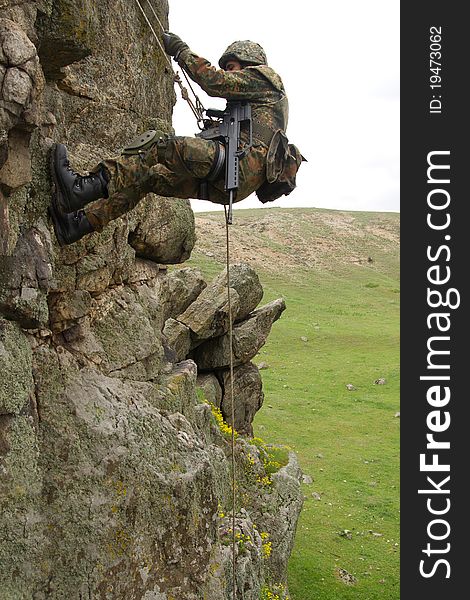 Military man does dangerous rappeling in combative ammunition. Military man does dangerous rappeling in combative ammunition