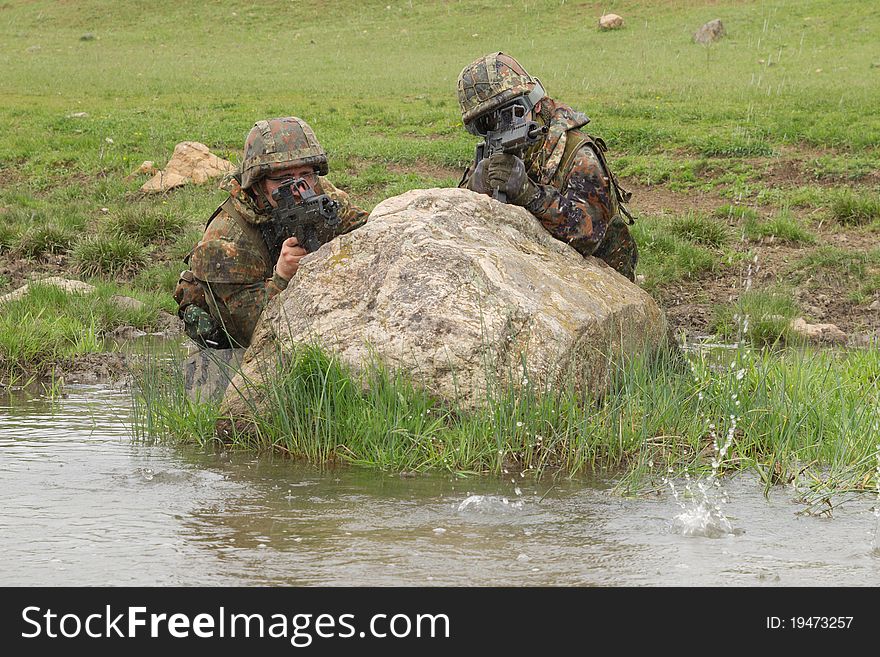 Soldiers covering behind the rock