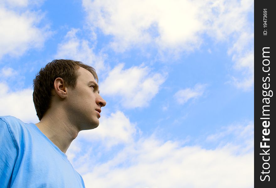 The young man looks at the blue sky